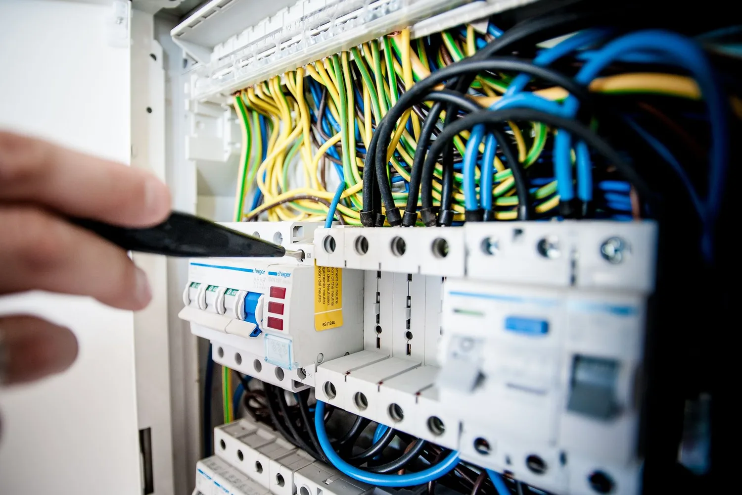 An electrician working inside an electrical distribution board