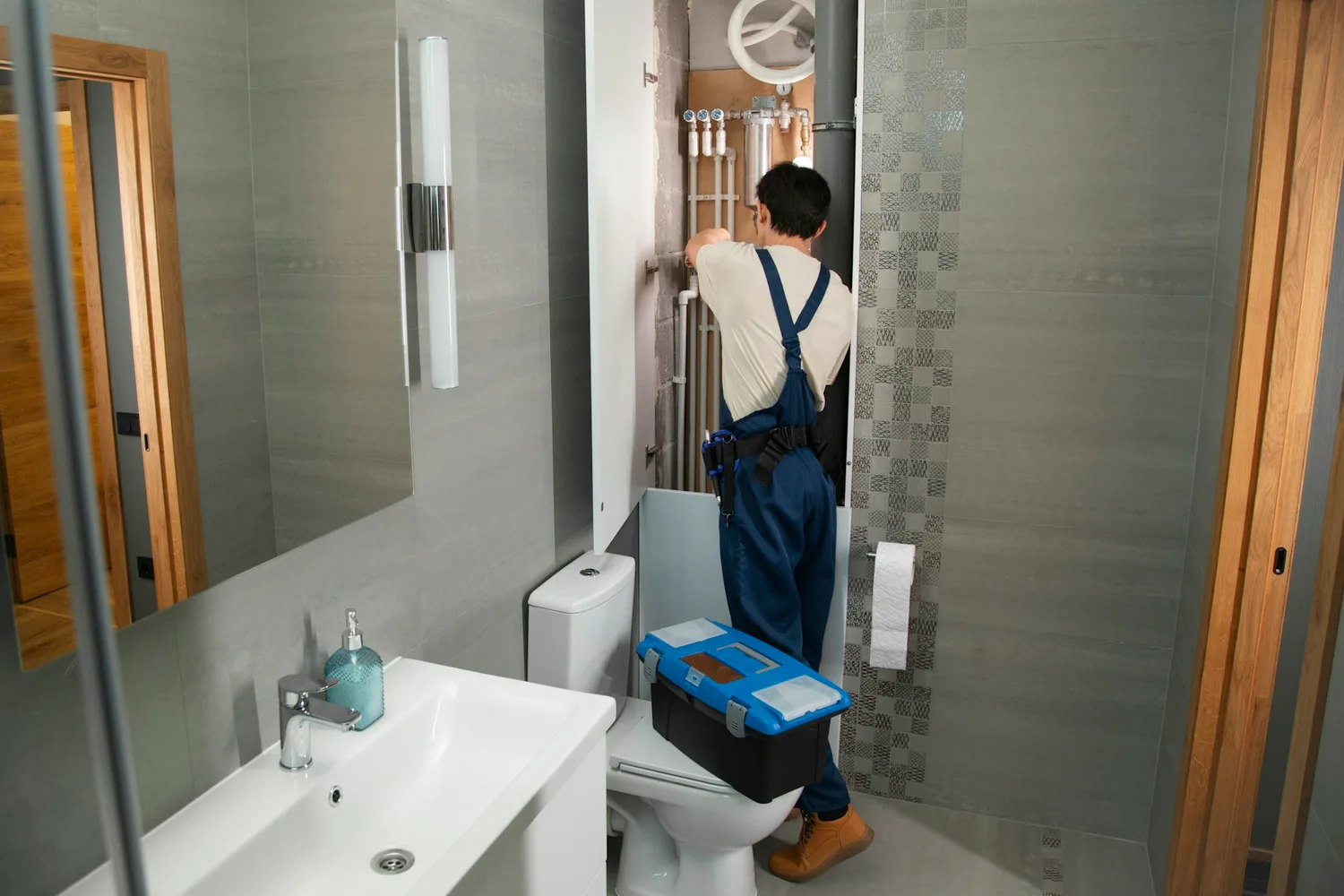 A plumber repairing pipework in a bathroom